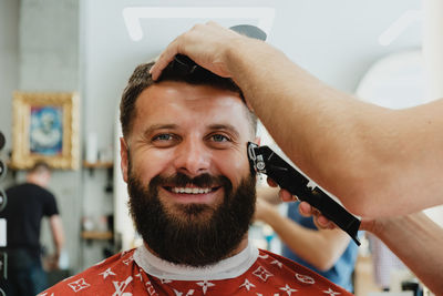 Smiling customer getting service in hair salon