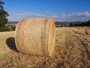 Hay bales on field against sky