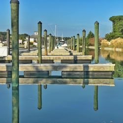 Reflection of built structure in water against clear blue sky