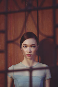 Portrait of young woman against wall