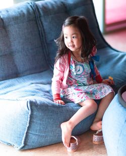 Portrait of girl sitting on sofa