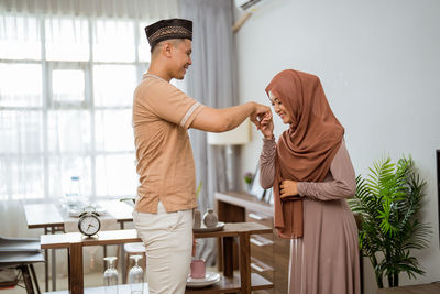 Woman holding hand of husband hand at home