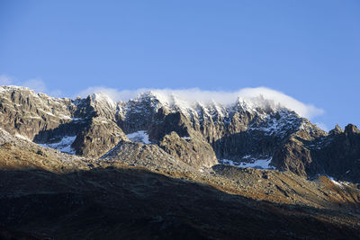 Scenic view of snowcapped mountains against blue sky