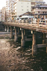 Bridge over river by buildings in city