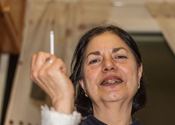 Portrait of a smiling woman holding camera