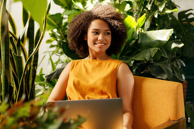 Portrait of smiling young woman using mobile phone