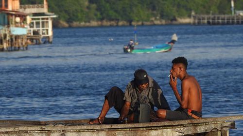 Men sitting on boat in sea