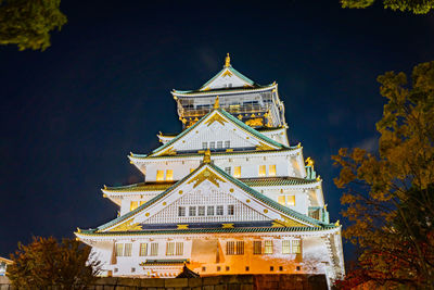 Low angle view of illuminated building against sky at night