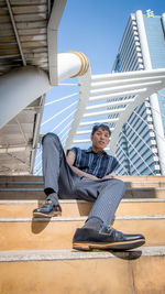 Low angle portrait of man sitting on steps