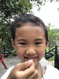 Portrait of boy smiling against trees