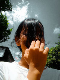 Close-up of woman hand against sky