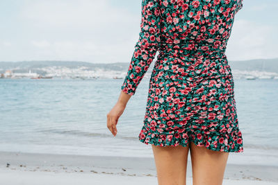 Rear view of woman standing at beach