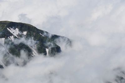 Low angle view of snowcapped mountains against sky