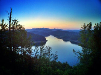 Scenic view of lake and mountains against sky