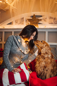 Woman with dog sitting at home