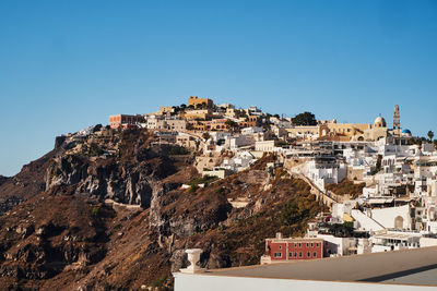 Buildings in town against clear sky