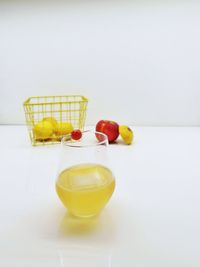 Close-up of yellow fruit on table against white background