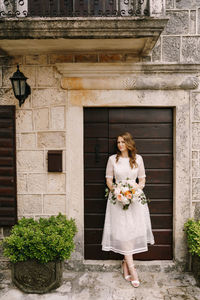 Full length of woman holding flower bouquet