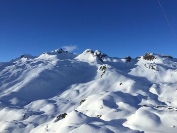 Scenic view of snowcapped mountains against clear blue sky