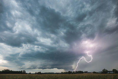 Lightning over field against sky