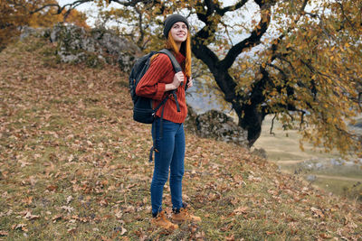 Full length of a smiling man standing in autumn