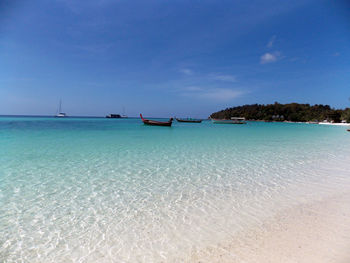 Boats moored in sea against sky