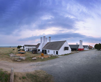 Buildings by road against sky