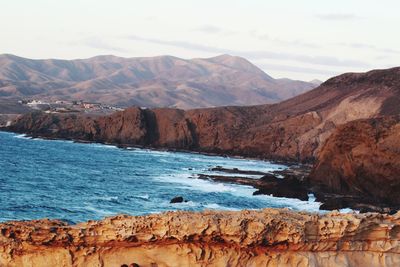 Scenic view of sea and mountains against sky