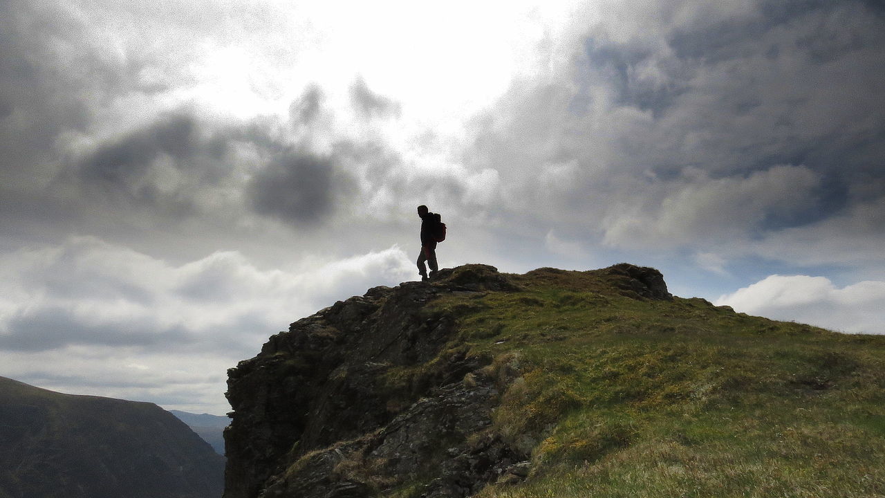 sky, cloud - sky, mountain, standing, nature, outdoors, hiking, adventure, day, beauty in nature, full length, landscape, one person, low angle view, scenics, people