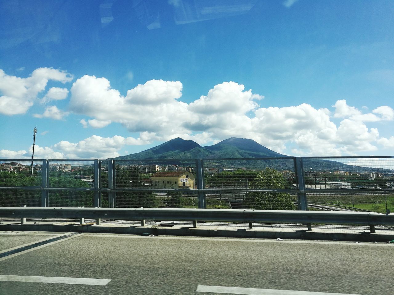 transportation, road, street, mountain, sky, bridge - man made structure, mountain range, city, cloud, day, blue, outdoors, elevated road, engineering, city life, cloud - sky, empty road