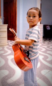 Portrait of boy playing okulele