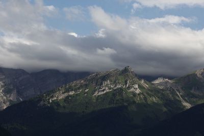 Scenic view of mountain range against cloudy sky