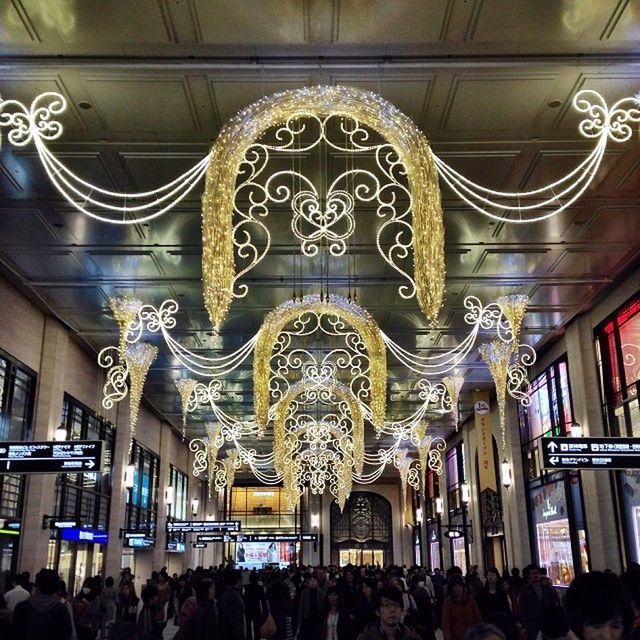 indoors, ceiling, large group of people, architecture, built structure, illuminated, person, men, interior, arch, lighting equipment, low angle view, famous place, architectural column, window, shopping mall, travel destinations, lifestyles, architectural feature