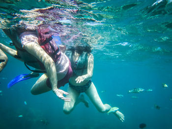 Friends scuba diving undersea