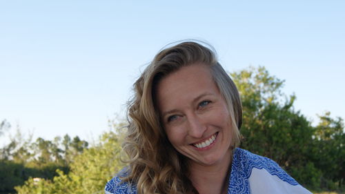 Smiling young woman against clear sky