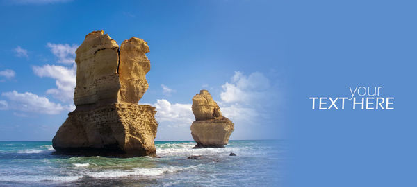 Panoramic view of rock formation in sea against blue sky