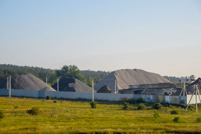 Houses on field against clear sky