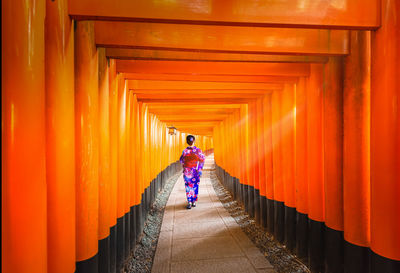 Rear view of woman walking on footpath