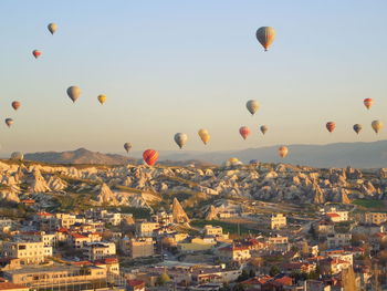 Hot air balloons flying over buildings in cappdocia