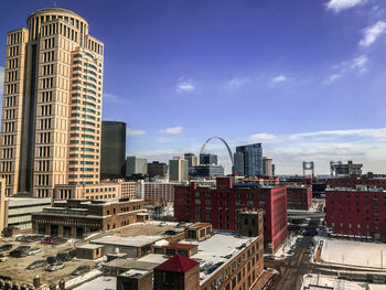Buildings in city against cloudy sky