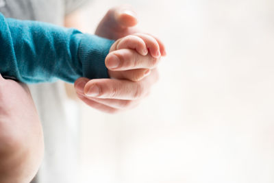 Close-up of baby holding person hands