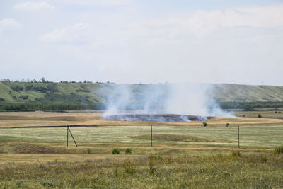 Scenic view of waterfall on field against sky