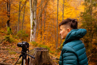 Man with arms raised in forest during autumn