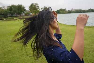 Woman tossing hair while standing outdoors