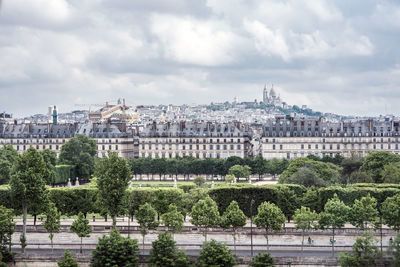 Buildings in city against cloudy sky