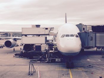 Airplane on airport runway against sky