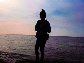 Silhouette of people on beach at sunset