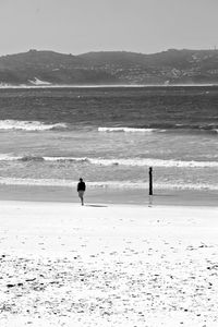 Silhouette people on beach against sea