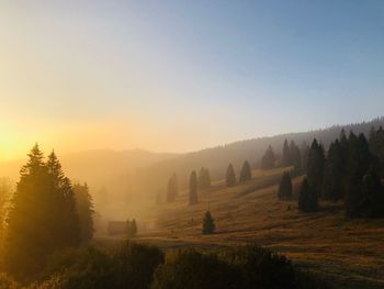 Scenic view of land against clear sky during sunset