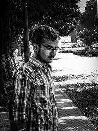 Portrait of young man standing by water